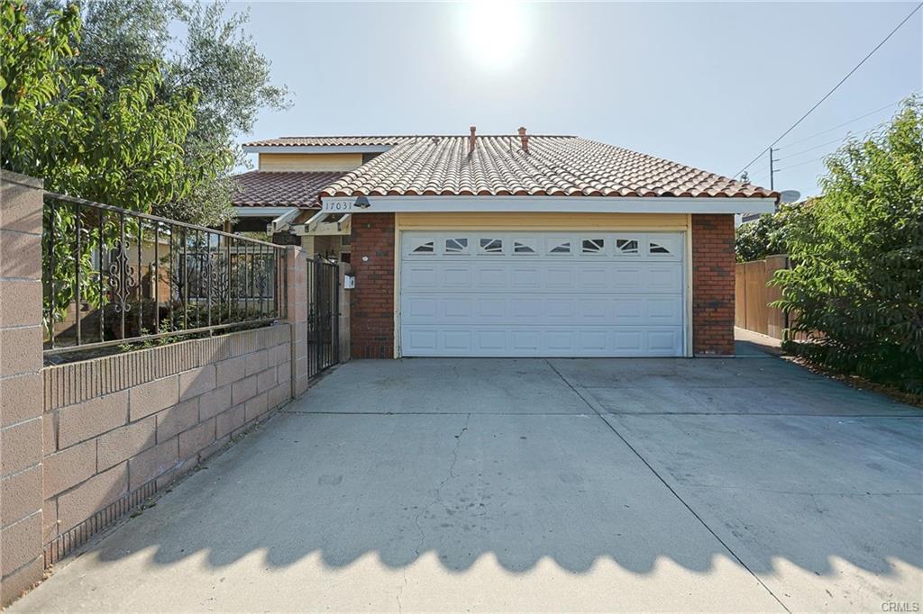 17031 Ward St — wide driveway and two-car attached garage beneath the newer red tile roof