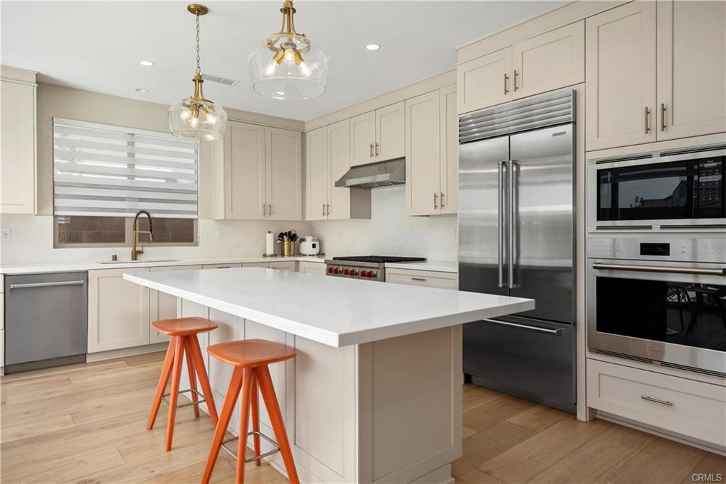 142 Sabbia — chef's kitchen with quartz island, Wolf range, and Sub-Zero refrigerator