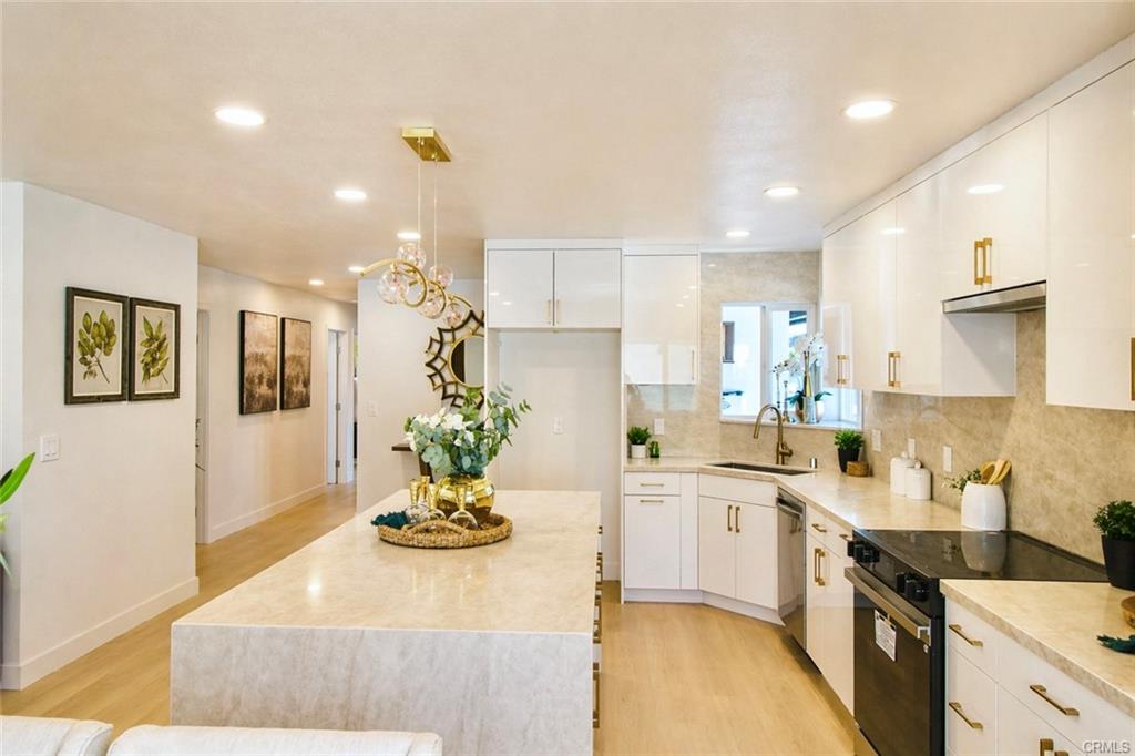 9142 Parliament Ave — upgraded kitchen with white cabinetry, gold fixtures, and stainless appliances