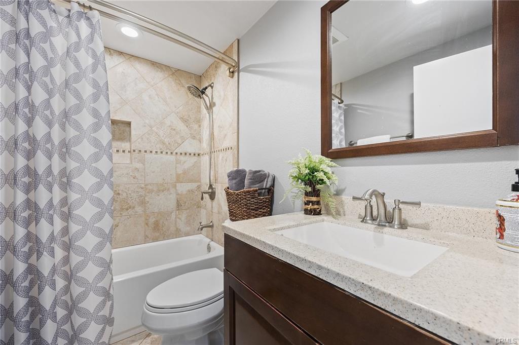 18126 Sand Dunes Ct — updated bathroom with stone counters and tiled tub surround