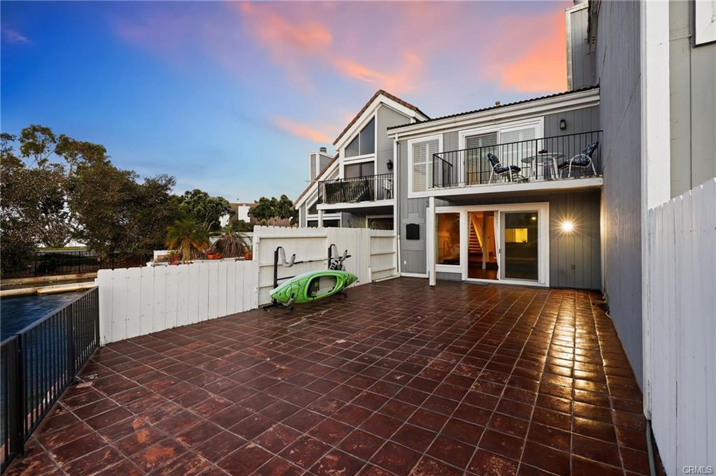 3631 Windspun Dr — expansive waterfront patio deck with kayak storage at sunset