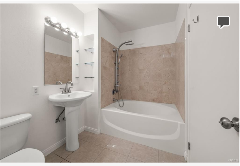 488 E Ocean Blvd #717 — bathroom with soaking tub and tiled surround