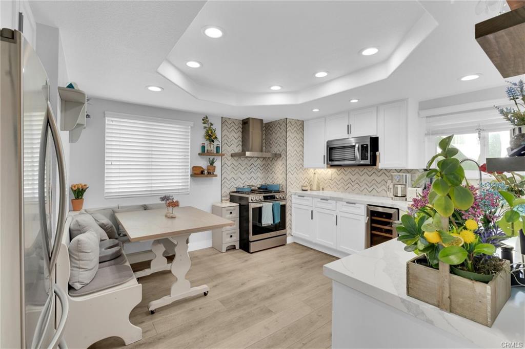 16276 Pacific Cir #B — kitchen detail with range, hood, and wine refrigerator