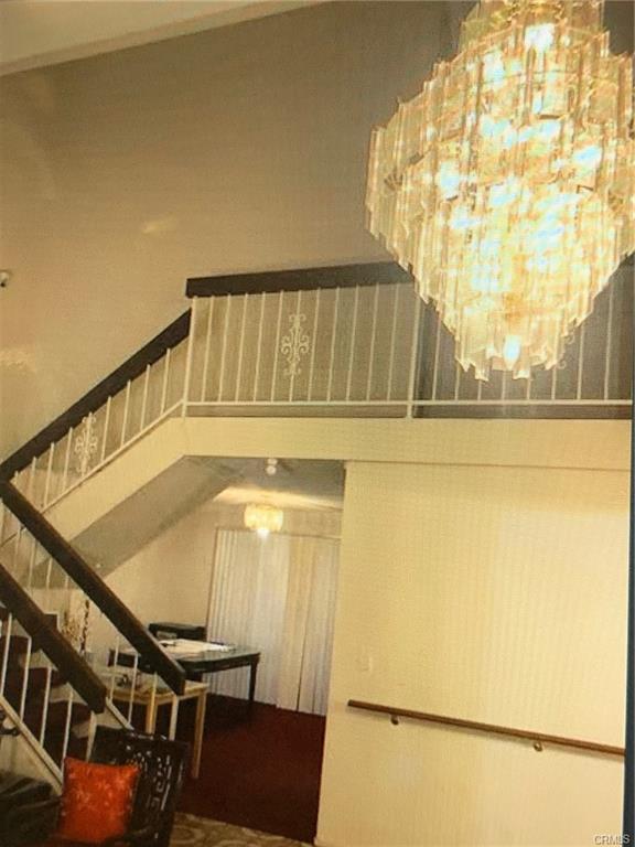 17031 Ward St — vaulted stairwell and upstairs landing with chandelier