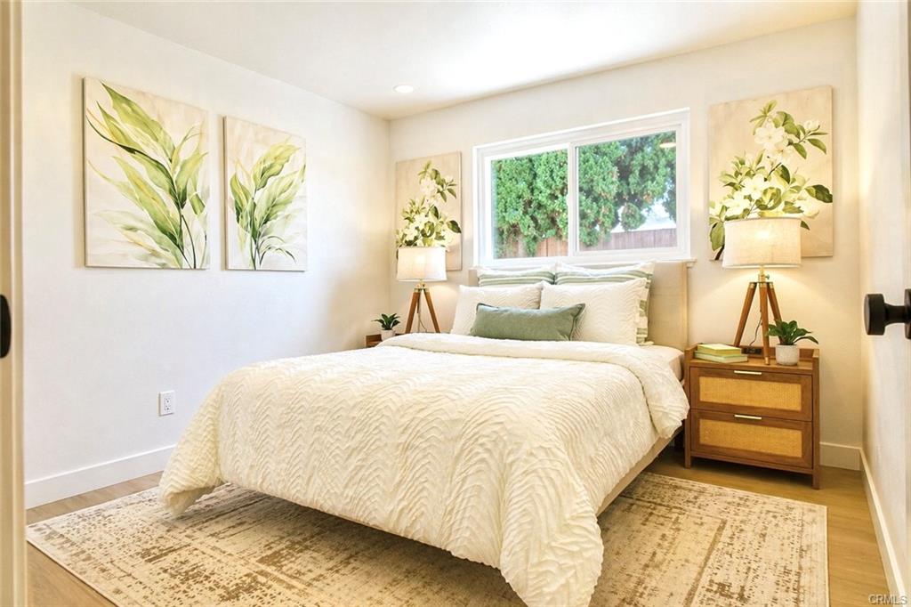 9142 Parliament Ave — bedroom with large window and light wood flooring