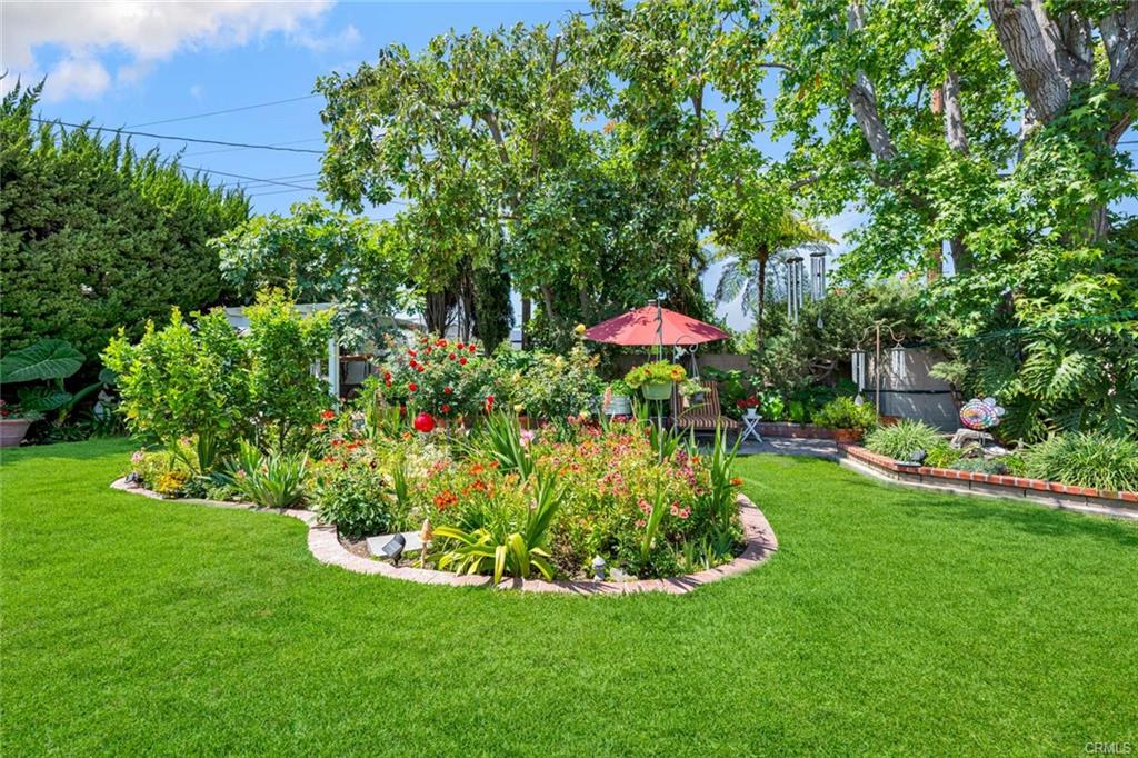 12231 Wilken Way — botanical backyard with flower beds, lawn, and mature trees