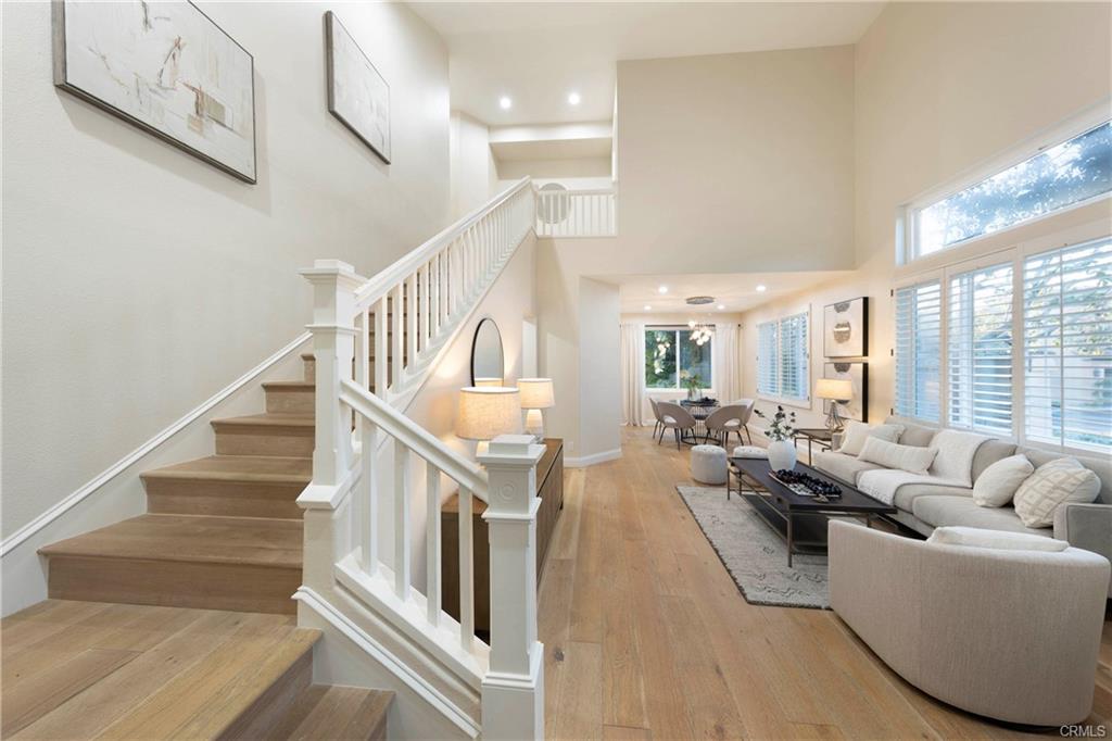 43 Lessay — entry and staircase opening to the living room with wide-plank hardwood floors