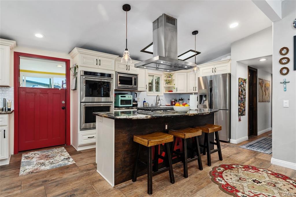 20292 Riverside Dr — remodeled kitchen with large island, stainless hood, and red entry door
