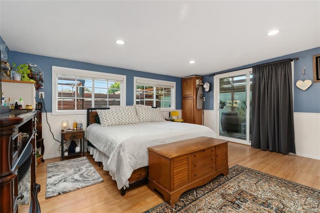 20292 Riverside Dr — primary bedroom with wide windows and wood flooring